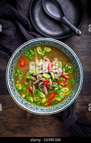 German liver dumpling soup with onion and vegetable on dark background Stock Photo