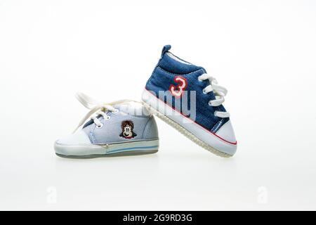 Blue shoes of a boy of different sizes. The composition is isolated on a white background. Stock Photo