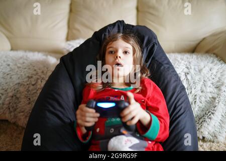 Gamer girl playing gamepad, joystick in games on big screen. Cybersport. A game of strategy and action Stock Photo