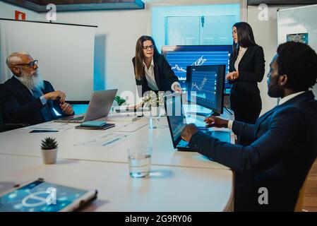 Diverse businesspeople discussing data in boardroom Stock Photo