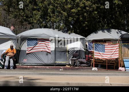 Los Angeles, CA USA - Julyl 3, 2021: Homeless veteran beside his tent on the permieter of the Veterans Administration grounds Stock Photo