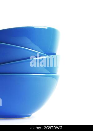 Stack of four blue ceramic bowls isolated on white. Close up shot. Stock Photo