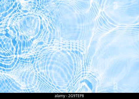 Surface of light blue transparent swimming pool water texture with circles on the water. Trendy abstract nature background. Water waves in sun light Stock Photo