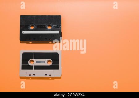 Two audio cassette tapes isolated on orange background. Copy space Stock Photo