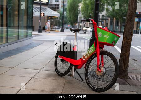 Seattle, USA. 27th Jul, 2021: A bike-share e-bike parked blocking a portion of the sidewalk. Frustration from pedestrians has grown since the new ride share bikes and scooters launched in Seattle. Complaints range from bikes blocking the handicapped safe access and passage, to the bikes being ridden on sidewalks endangering pedestrians. Credit: James Anderson/Alamy Live News Stock Photo