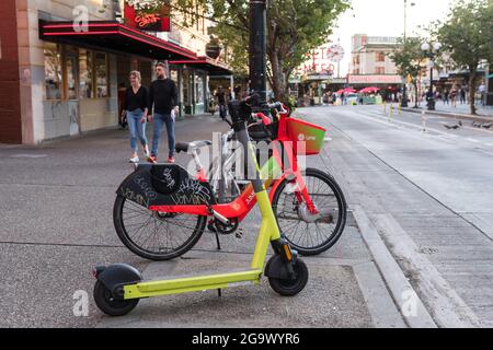 Seattle, USA. 27th Jul, 2021: Bike-share e-bike parked by a bike rack on the sidewalk. Frustration from pedestrians has grown since the new ride share bikes and scooters launched in Seattle. Complaints range from bikes blocking the handicapped safe access and passage, to the bikes being ridden on sidewalks endangering pedestrians. Credit: James Anderson/Alamy Live News Stock Photo