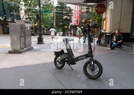 Seattle, USA. 27th Jul, 2021: A bike-share e-bike parked blocking a portion of the sidewalk. Frustration from pedestrians has grown since the new ride share bikes and scooters launched in Seattle. Complaints range from bikes blocking the handicapped safe access and passage, to the bikes being ridden on sidewalks endangering pedestrians. Credit: James Anderson/Alamy Live News Stock Photo