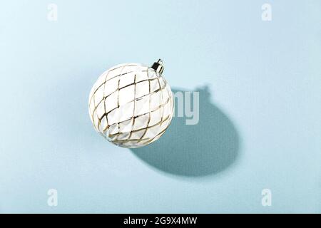 Minimalistic Christmas composition. One white Christmas ball on blue background with shadow. Stock Photo