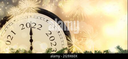 New Year 2022 clock and fireworks background.