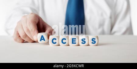 Businessman arranging the wooden cubes with the word access. Business accessibility concept. Stock Photo
