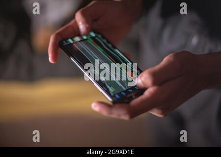 Person seen using mobile phone to trade  Stock Photo