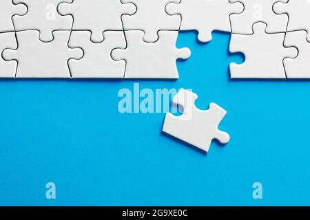 Missing puzzle piece on blue background with copy space. Stock Photo
