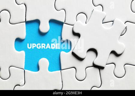 The word upgrade on a missing puzzle piece. To upgrade a software or hardware concept. Stock Photo