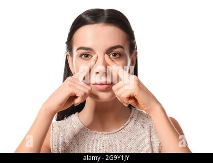 Young woman doing face building exercise against white background Stock Photo