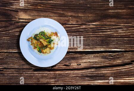 Stir Fried Basil with Crispy Pork on Rice. Put a plate and place it on the table for eating. It is both street food and fast food. Stock Photo