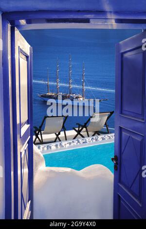 Santorini island view with ship against swimming pool in Greece Stock Photo