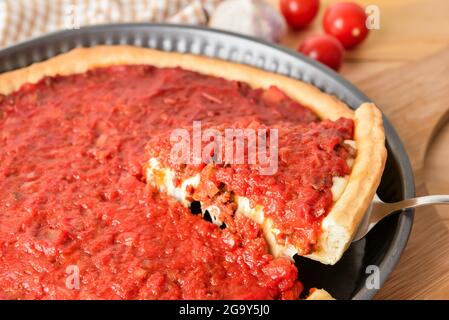 Baking dish with tasty Chicago-style pizza on table, closeup Stock Photo