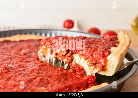 Baking dish with tasty Chicago-style pizza on light background, closeup Stock Photo