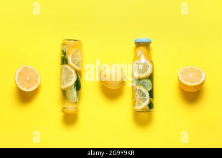 Bottles with cucumber lemonade on color background Stock Photo