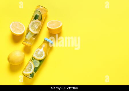 Bottles with cucumber lemonade on color background Stock Photo