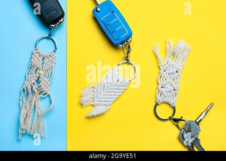 Keys with handmade cotton keychains on color background Stock Photo
