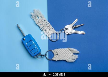 Keys with handmade cotton keychains on color background Stock Photo