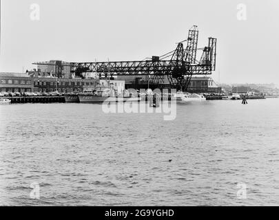 The coal unloading gantries on Poole Quay. Two naval patrol vessels are ...