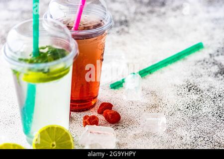 Strawberry lemonade and lime with mint lemonade on a  table with ice cubes, fresh lime and strawberries Stock Photo