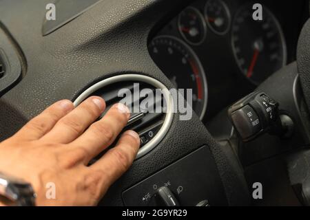 Male hand close-up adjusts the air conditioner in the car, car interior Stock Photo