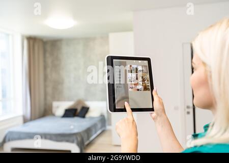 Woman pressing on smart home automation panel monitor Stock Photo