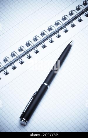 black ballpoint pen on a spiral notebook Stock Photo