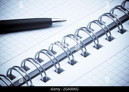 black ballpoint pen on a spiral notebook Stock Photo