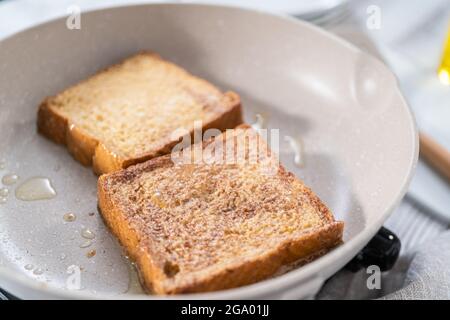 Frying french toast in a nonstick frying pan. Stock Photo