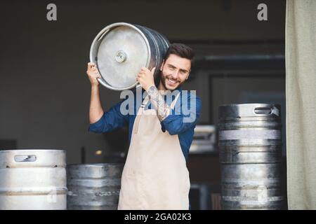 Strong warehouse worker, brewery owner working at plant, small business and success emotions Stock Photo
