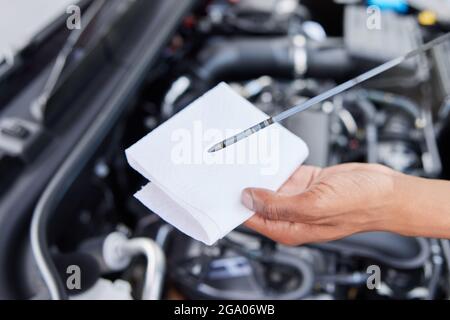 Close-Up Of Man Checking Car Engine Oil Level On Dipstick Stock Photo