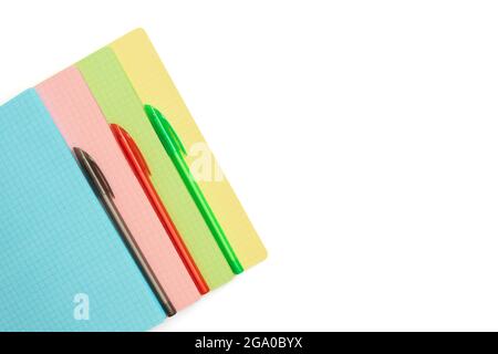 Colored checkered sheets and pens isolated on a white background. Stationery school supplies. Copy space, top view, flat lay. Stock Photo