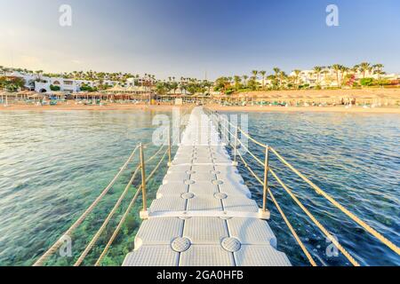 Pontoon with handrails through coral reef to the sea on tropical beach resort. Relaxing in the red sea, Egypt Stock Photo