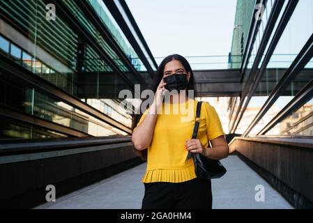 Woman talking on the phone in front of a corporate building Stock Photo