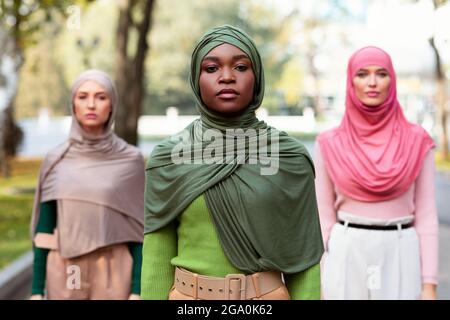 Three Serious Diverse Muslim Women Looking At Camera Standing Outdoors Stock Photo