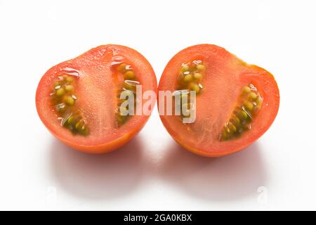 split cherry tomato on white background Stock Photo