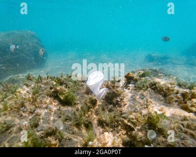 Discarded plastic cup floating on contaminated sea ecosystem,environmental nature pollution Stock Photo