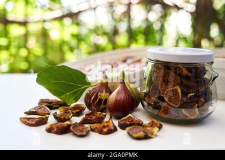 Fresh figs lie on the table next to dried figs in a glass jar Stock Photo
