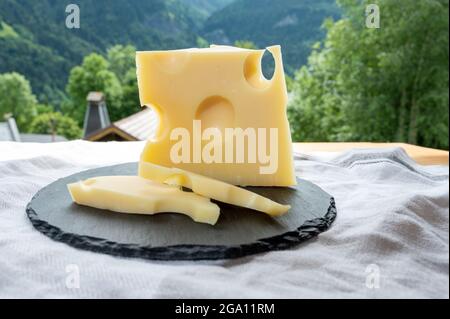 Cheese collection, French cow cheese emmental and french mountains village in Haute-Savoie in summer on background Stock Photo