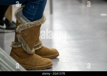 Closeup shot of female feet with winter brown boots in the subway train Stock Photo