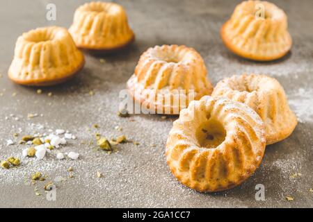 Homemade delicious mini lemon bundt cakes (muffins) on gray concrete background Stock Photo