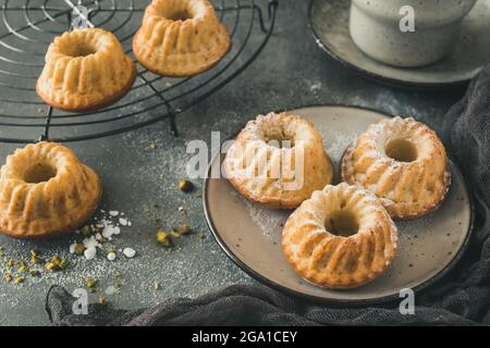 Homemade delicious mini lemon bundt cakes (muffins) on gray concrete background Stock Photo