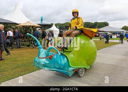 A man riding a large mechanical snail at Tatton Flower Show, Tatton Park, Cheshire, England, UK Stock Photo