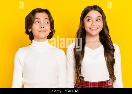 Photo portrait of children looking at each other in casual clothes isolated on bright yellow color background Stock Photo