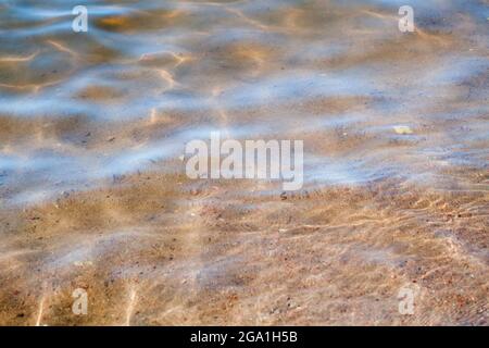 Sandy seabed is under shallow water with refraction ripple pattern Stock Photo