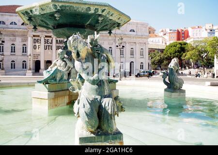 Sculptures of the North fountain in the Rossio Square, Queen Maria II National Theatre in the background, Lisbon, Portugal Stock Photo